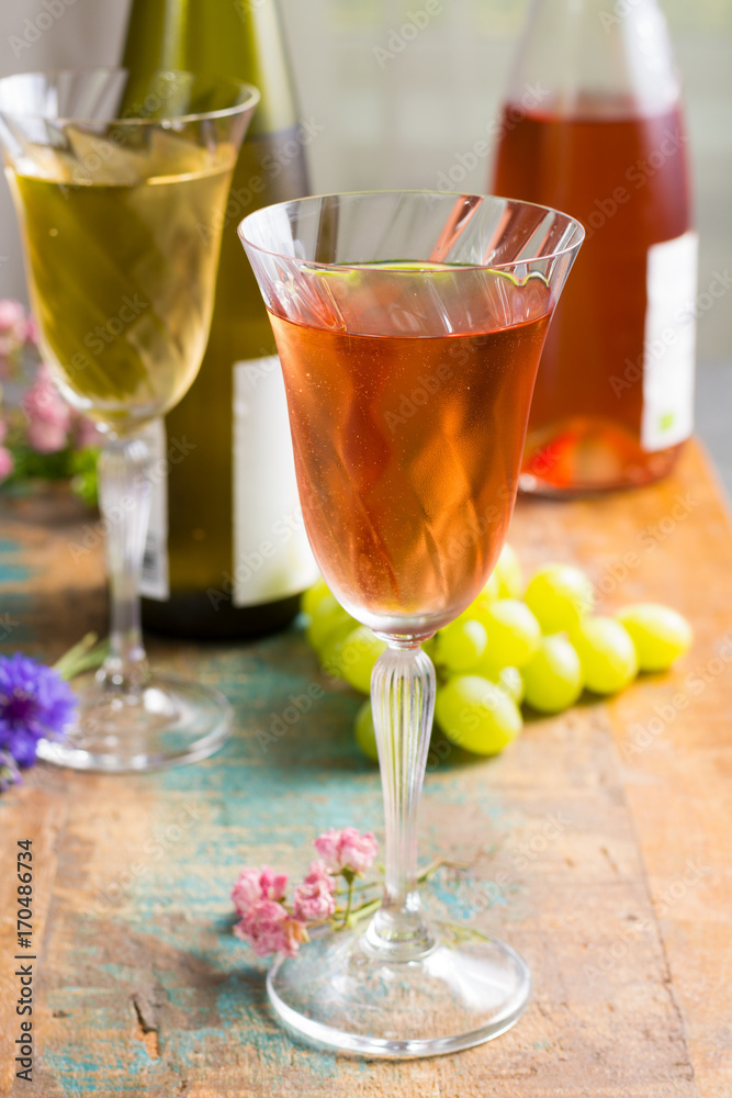 Cold summer wines, white and rose, served in beautiful glasses on terrace in cafe with romantic flowers