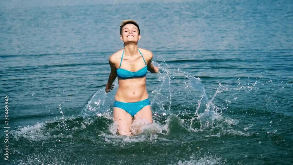 Beautiful girl splashes water in the sea. Beautiful girl splashes water in the sea.