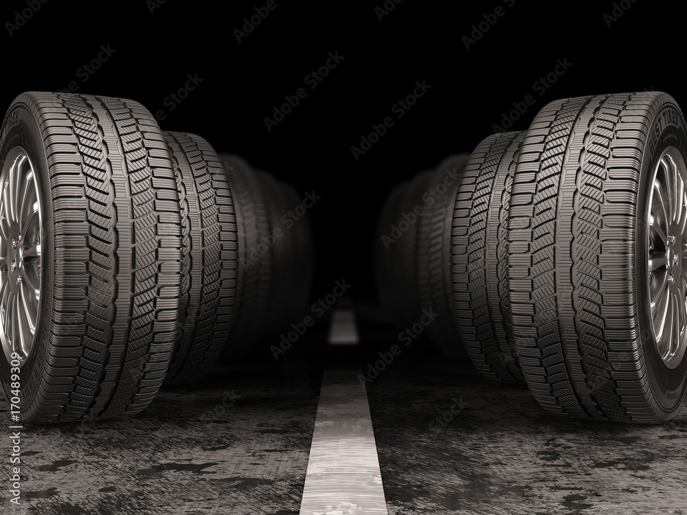 Car tires standing on the road on black background. Car tires standing on the road on black background.