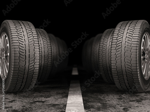Car tires standing on the road on black background.