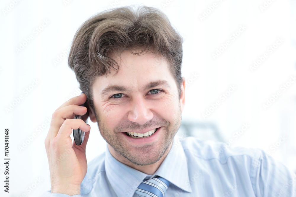Confident businessman talking on the phone and smiling at camera Confident businessman talking on the phone and smiling at camera