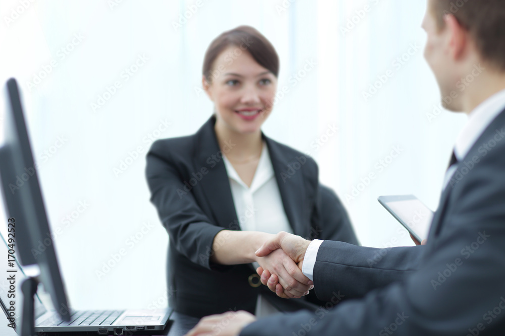 Modern pretty business woman shaking hands in a bright office Modern pretty business woman shaking hands in a bright office
