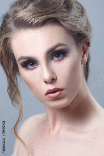 Beauty portrait of a beautiful girl on a gray background.