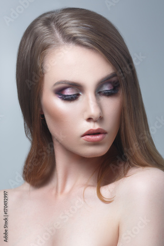 Beauty portrait of a beautiful girl on a gray background.