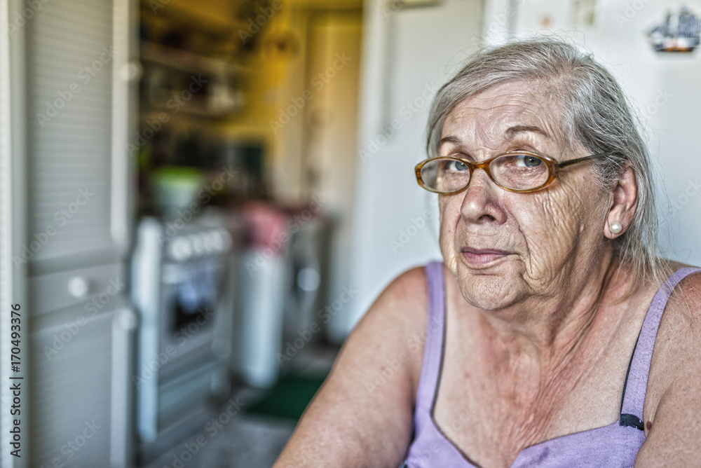 Pensive female pensioner looking into the camera Pensive female pensioner looking into the camera