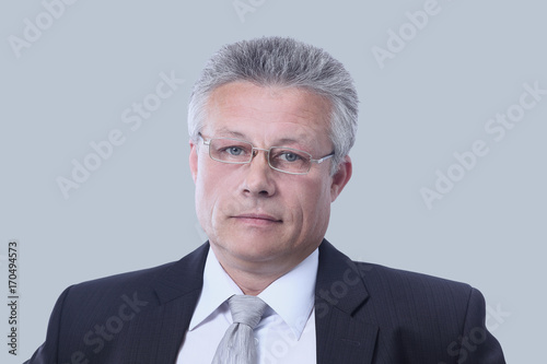 Gray-haired business man smiling isolated on gray background.