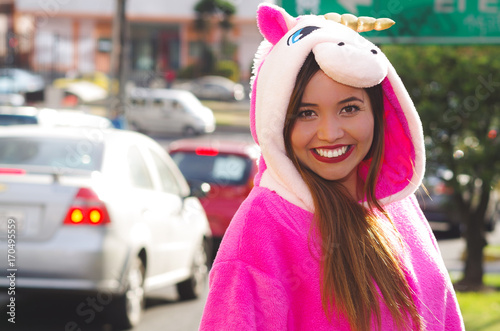 Portrait of a beautiful smiling young woman wearing an unicorn costume, at outdoors in the city of Quito