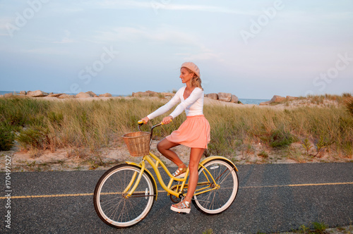 Beatiful woman with bike on the beach