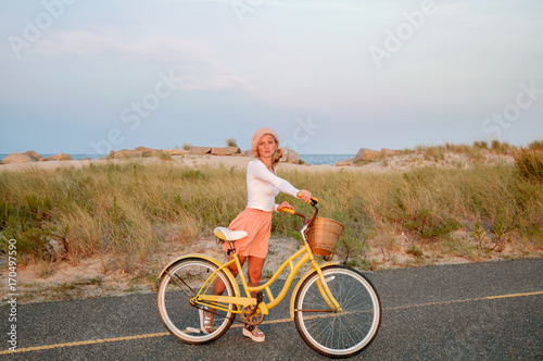 Beatiful woman with bike on the beach