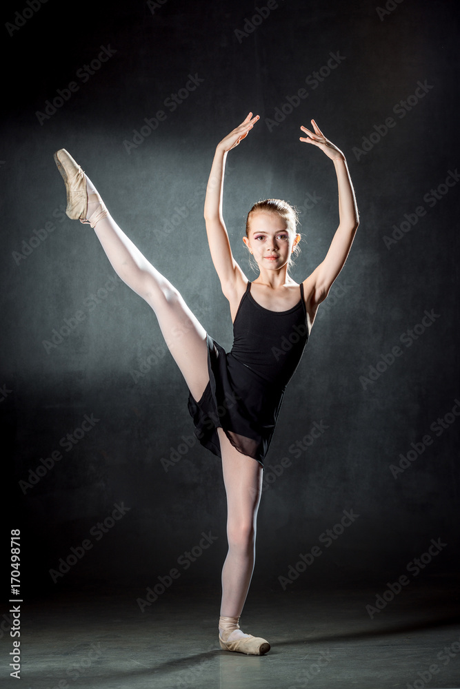 Ballerina. Cute little girl posing and dancing in studio. The girl is studying ballet.