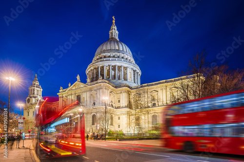 London, England - Beautiful Saint Paul's Cathedral with iconic red double decker buses on the move at night
