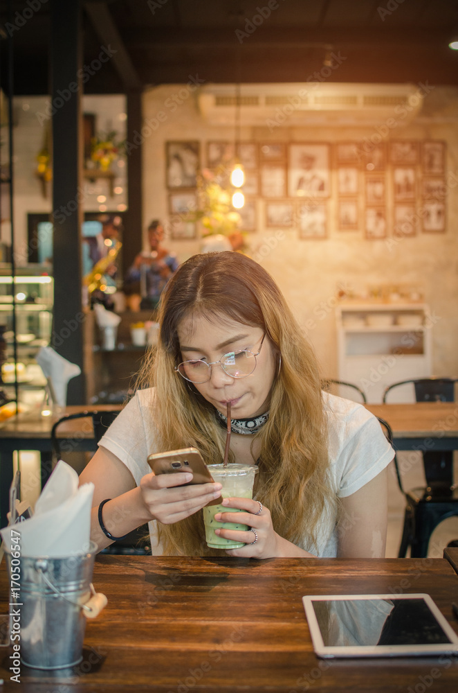 girl using tablet on wooden table in cafe girl using tablet on wooden table in cafe