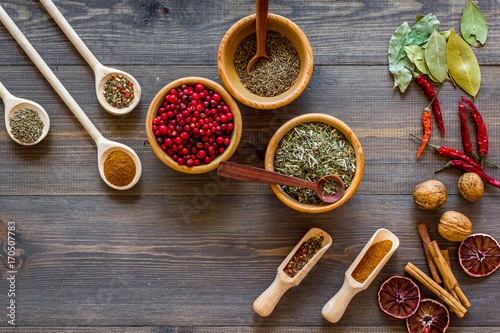 Fototapeta Naklejka Na Ścianę i Meble -  Colorful dry herbs and spices for cooking food wooden kitchen table background top view