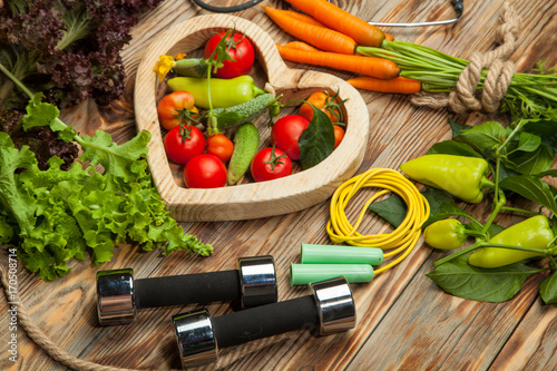 Raw vegetables, diet and sport on a wooden background