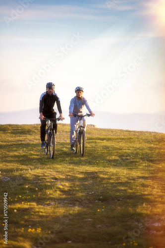 Happy mountainbike couple outdoors have fun together on a summer afternoon