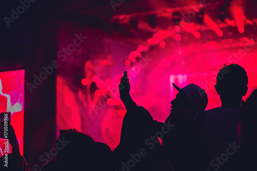 A man makes a selfie on the background of a rock concert photo