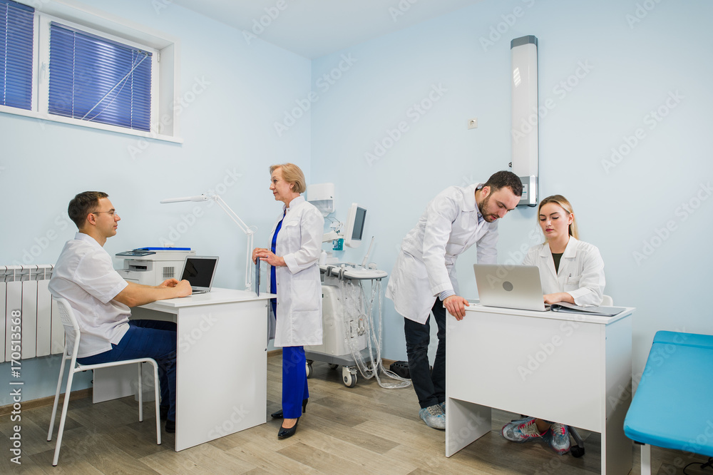 Group Of Doctors Involved In Serious Discussion With Medical Records Group Of Doctors Involved In Serious Discussion With Medical Records
