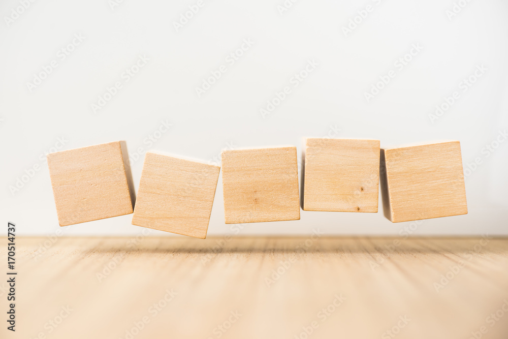 Business concept - Abstract geometric real floating wooden cube on grey background and it's not 3D render, float on wood floor white background for display or montage word. Business concept - Abstract geometric real floating wooden cube on grey background and it's not 3D render, float on wood floor white background for display or montage word.