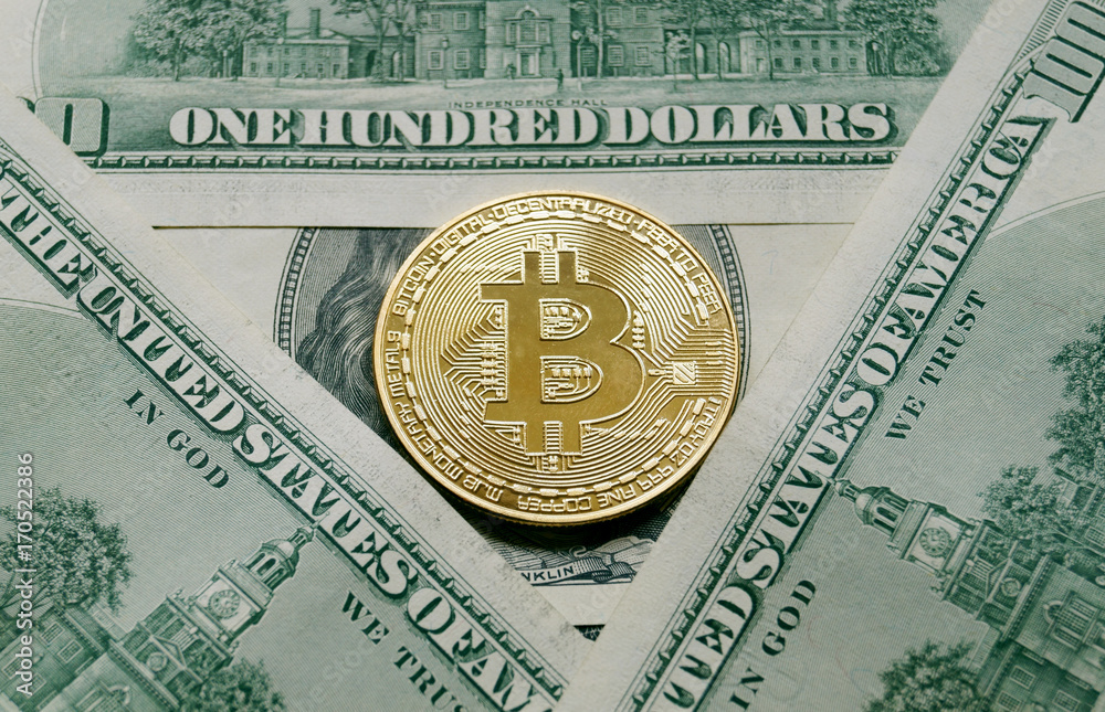 A symbolic coins of bitcoin on banknotes of one hundred dollars.