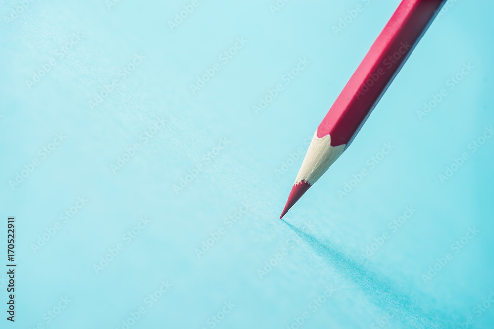 Business concept - one red color pencil stand on blue paper background. It's symbol of key point and confident. Business concept - one red color pencil stand on blue paper background. It's symbol of key point and confident.