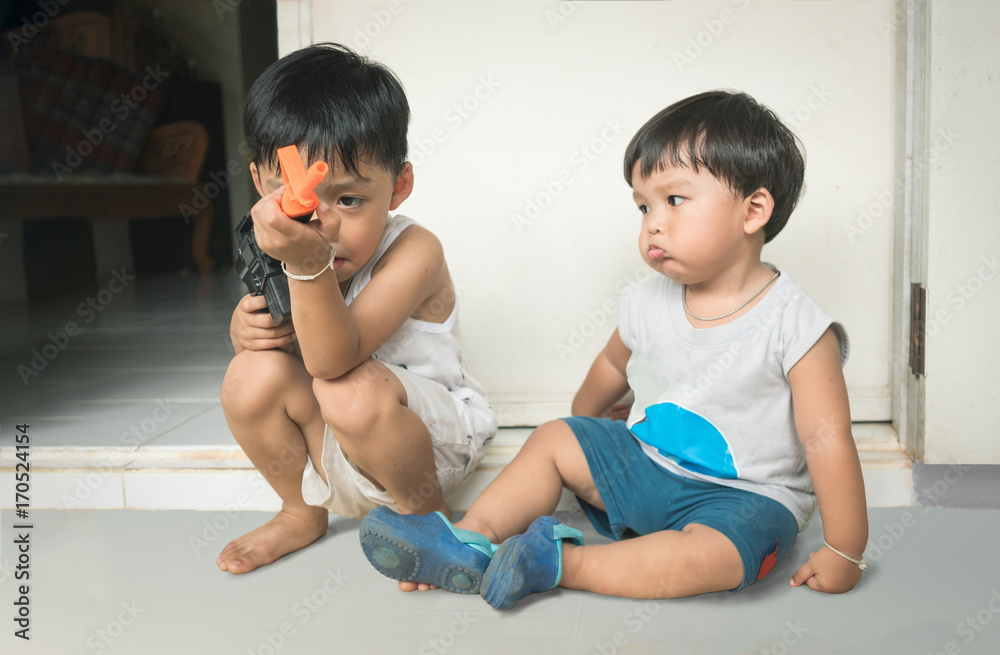 Two little brother playing gun together Two little brother playing gun together