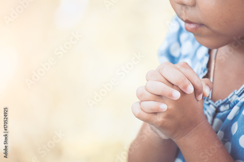 Cute asian little child girl praying with folded her hand for faith,spirituality and religion concept