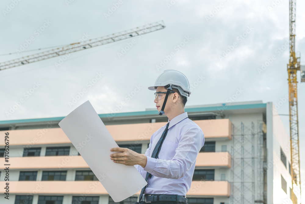 smiling young architect or engineering builder in hard hat with tablet over group of builders at construction site, architect watching some a construction, business, building, industry, people concept smiling young architect or engineering builder in hard hat with tablet over group of builders at construction site, architect watching some a construction, business, building, industry, people concept