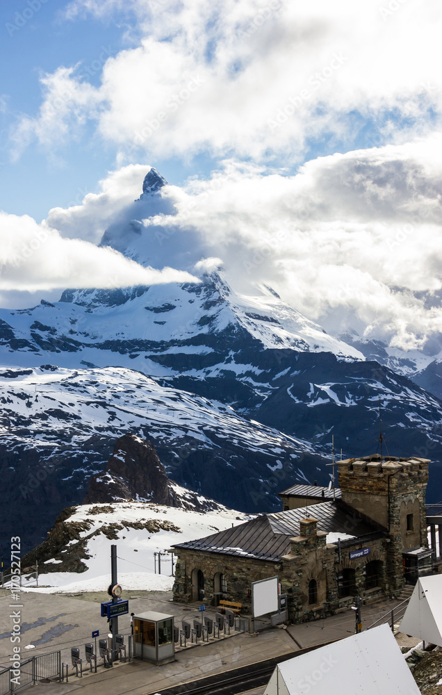 Majestic Dreamy View of snowy Gornergrat station and the iconic Matterhorn Peak shrouded with clouds, Zermatt, Switzerland, Europe.
