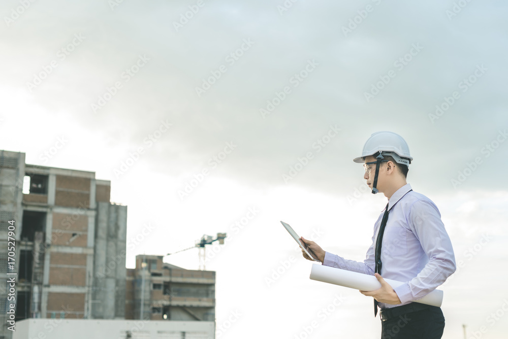 smiling young architect or engineering builder in hard hat with tablet over group of builders at construction site, architect watching some a construction, business, building, industry, people concept smiling young architect or engineering builder in hard hat with tablet over group of builders at construction site, architect watching some a construction, business, building, industry, people concept