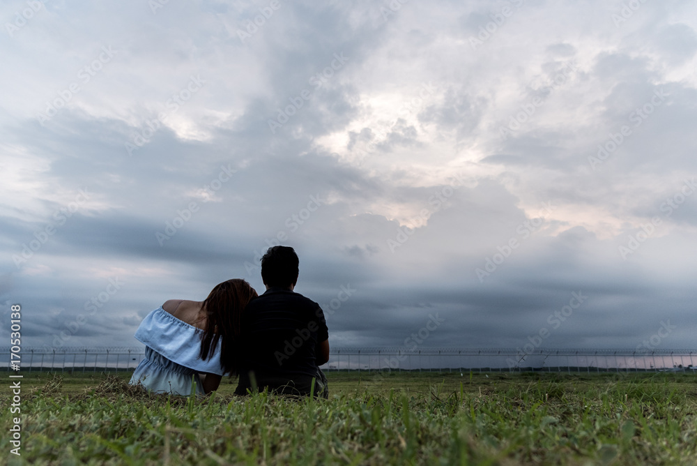 woman and man relax and siting on park with sunset and cloud sky thinking and concentrate in sunset background with copy space concept. woman and man relax and siting on park with sunset and cloud sky thinking and concentrate in sunset background with copy space concept.