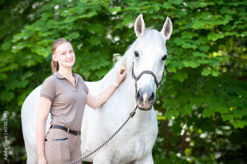 Portrait of beautiful white horse with pretty young teenage girl
