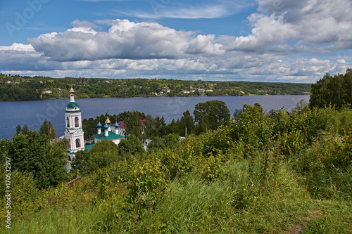 Orthodox temple on the river bank/The white Orthodox church stands on the river bank. View of the church from the top of the hill. Plyos, Ivanovo region, Russia. The Golden ring of Russia photo