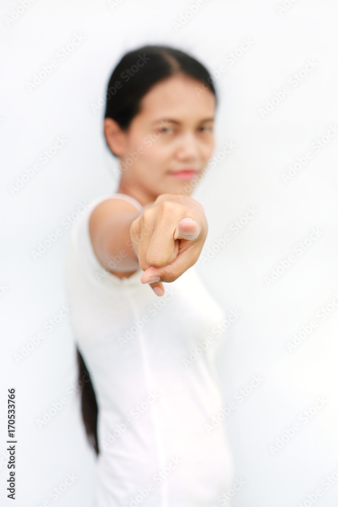 Young asian woman in T-Shirt pointing finger at you on white background, Selected focus at her finger. Young asian woman in T-Shirt pointing finger at you on white background, Selected focus at her finger.
