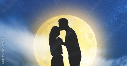Silhouettes of a young couple under the starry sky with full Moon.