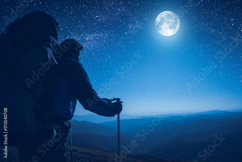 A hiker contemplate the full moon