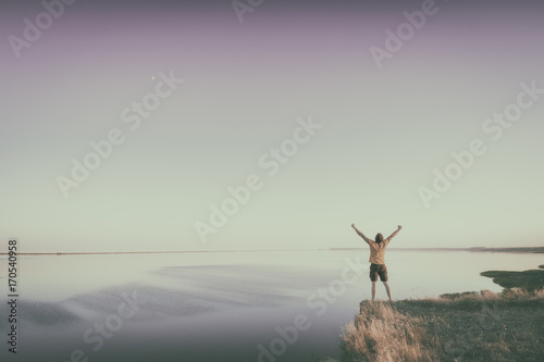 Man standing on a edge of precipice. Instagram stylization