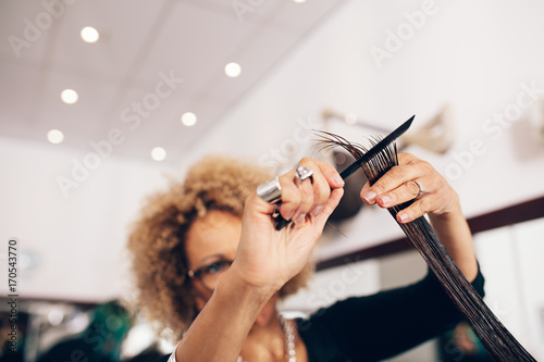 Female hair stylist cutting woman 's hair at salon