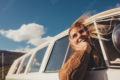 Traveling female driving the van and enjoying road trip photo