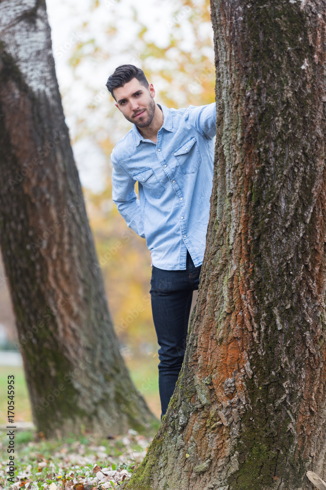 Handsome happy man in the park. Autumn scenery Handsome happy man in the park. Autumn scenery