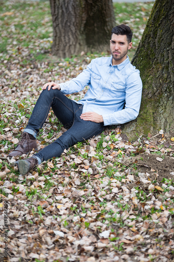 Handsome sad man in the park. Autumn scenery Handsome sad man in the park. Autumn scenery