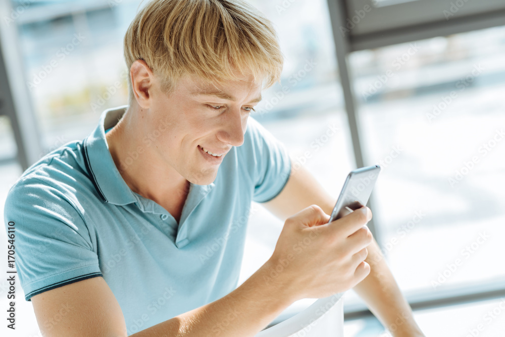Close up of young blonde man using his smart phone Close up of young blonde man using his smart phone