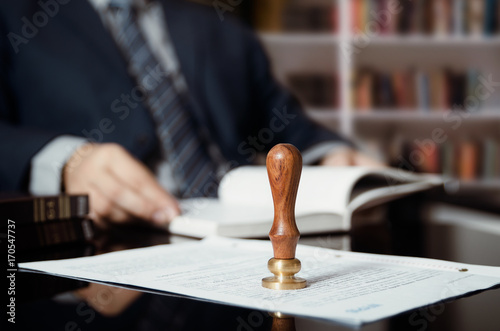 Businessman writing testament at notary public office photo