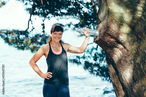 Pretty young sports woman is engaged in fitness on the seafront. Summer vacation with health benefits.