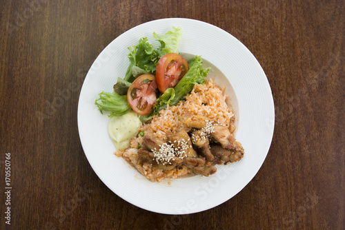 fried rice chicken with potato and vegetable in white dish on wooden table.Asian fried rice nasi goreng with chicken.