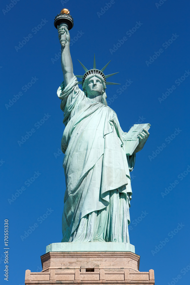 Fototapeta premium Statua Wolności z widokiem z przodu cokole w słoneczny dzień, błękitne niebo w Nowym Jorku