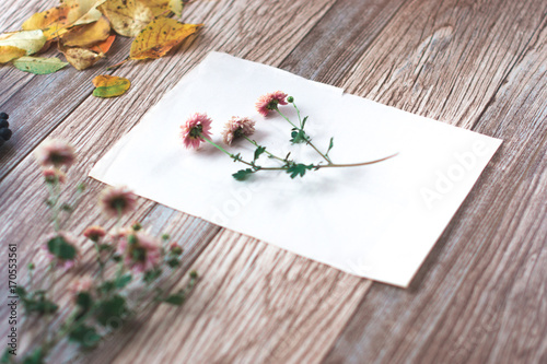 Dried flowers with autumn leaves on a wooden background.