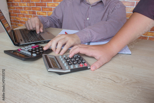 Young Business people Calculating Finance Bills In Office