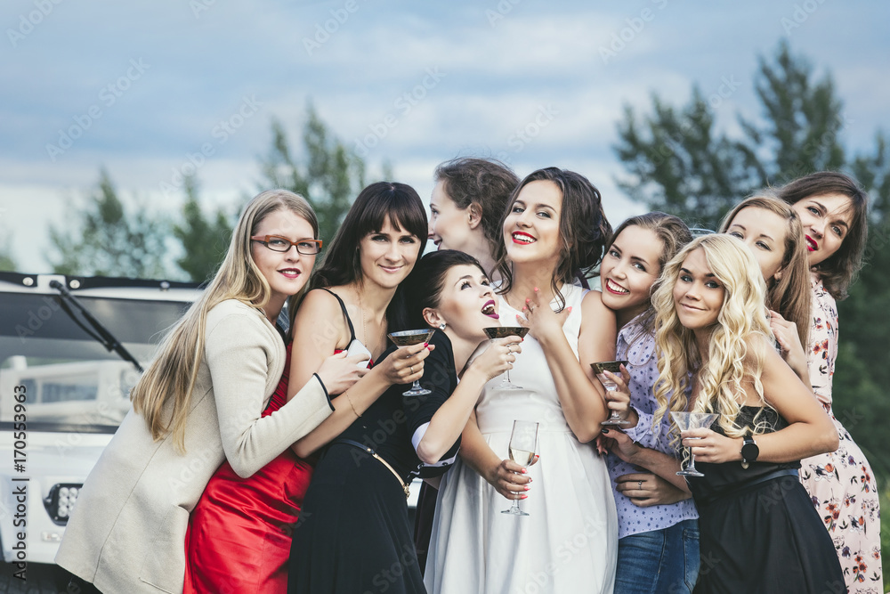 Young beautiful happy women celebrate bachelorette party in a convertible limousine