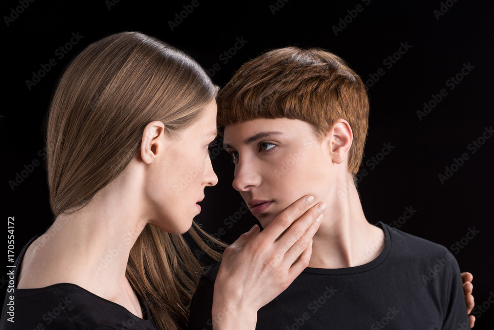 Young woman holding girlfriend by chin
