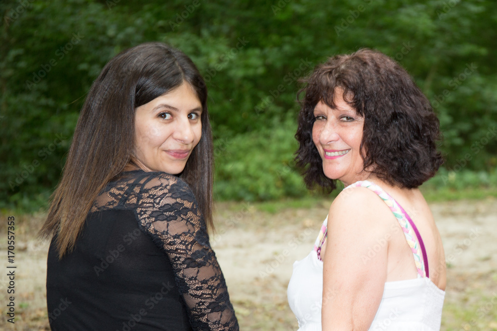 senior mother retired with daughter sit on bench park together